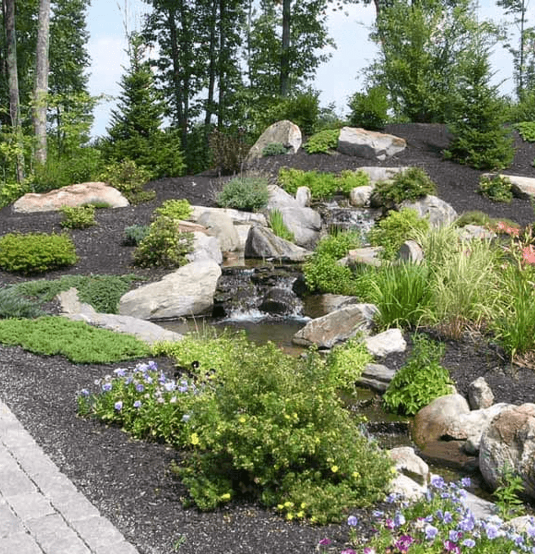 newly installed landscape with plants and stonework