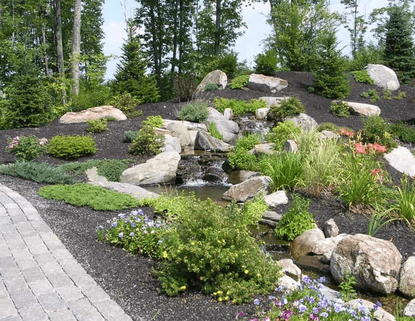newly installed landscaping with plants and stonework